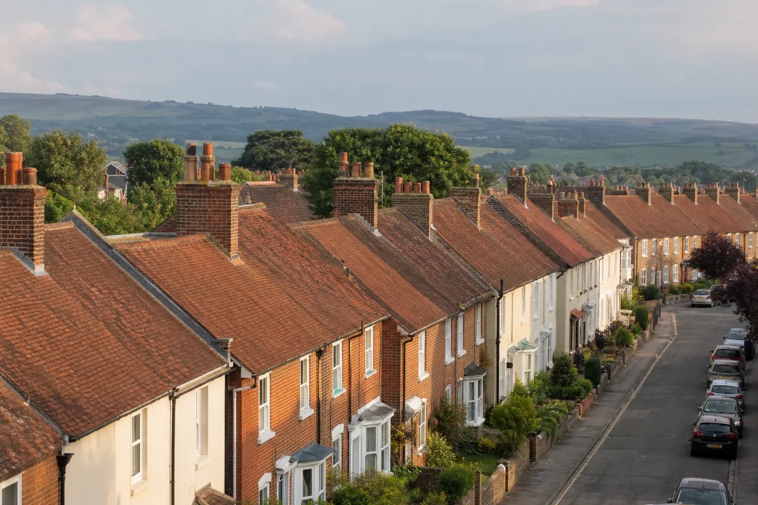 Rows of traditional British terraced houses with red clay tiled pitched roofs and brick chimney stacks